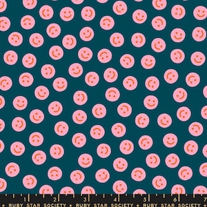 May include: Teal fabric with a repeating pattern of pink smiley faces. Each smiley face has an orange mouth. The fabric is from the Ruby Star Society.