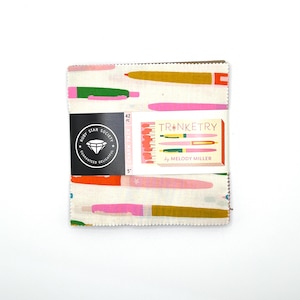 May include: A fabric charm pack with a white background and colorful pen-like designs in pink, green, orange, and yellow. The pack is labeled "Trunketry" by Melody Miller and includes a Ruby Star Society logo. Each square measures 5 inches.