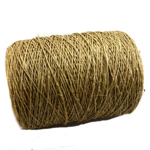 May include: A roll of natural brown twine, a type of string made from natural fibres, is shown against a white background.
