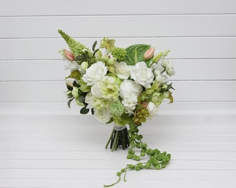 May include: A white and green bridal bouquet with white roses, green foliage, and a long green garland.