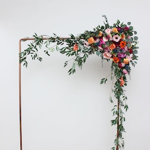 Jewel-tone wedding Emerald green orange pink magenta archway flowers Arbor flowers Pergola flowers Flower arrangement