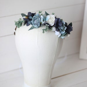 Pu&ograve; includere: Una corona floreale blu e bianca con foglie di eucalipto. La corona &egrave; realizzata con fiori di seta ed &egrave; perfetta per un matrimonio o un'occasione speciale.