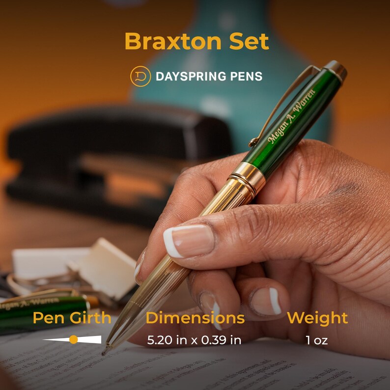 Puede incluir: Un bol&iacute;grafo verde y dorado con una inscripci&oacute;n personalizada "Megan A. Warren" y el texto "Braxton Set" y "DAYSPRING PENS". El bol&iacute;grafo mide 13,2 cm de largo y 1 cm de di&aacute;metro y pesa 28 gramos.