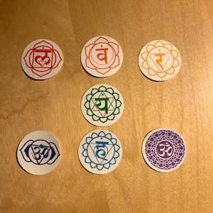 May include: Seven round, colorful paper circles with Sanskrit symbols and geometric designs. Each circle represents a chakra, a spiritual energy center in the body.