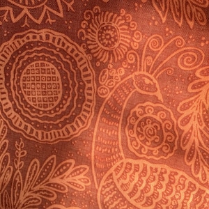 以下が含まれることがあります： スタイリッシュな孔雀と花柄が繰り返される茶色の生地。生地は質感があり、ヴィンテージな雰囲気です。