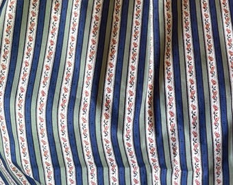 May include: Close-up of fabric with vertical stripes in blue, green, and white. Thin stripes of red flowers and black leaves run along the white stripes. The fabric has a vintage or cottagecore aesthetic.