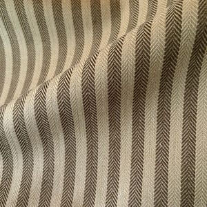 K&ouml;nnte beinhalten: Nahaufnahme eines Stoffes mit vertikalem Streifenmuster. Die Streifen wechseln sich zwischen einem hellen Beige und einem dunkleren Braun ab und erzeugen ein strukturiertes Fischgr&auml;tgewebe. Der Stoff ist leicht zerknittert und verleiht dem Design Tiefe.