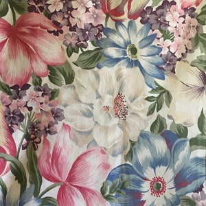 May include: A floral fabric with a white background and a variety of pink, blue, and green flowers. The flowers are arranged in a random pattern and include tulips, roses, and daisies.