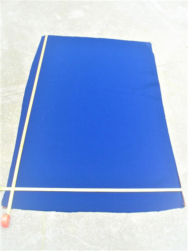 May include: A large, bright blue fabric rectangle with a measuring tape along the edge.