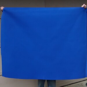 May include: A large, bright blue fabric backdrop, perfect for photography or video shoots.