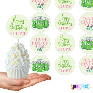 Puede incluir: Un conjunto de 10 adornos redondos para cupcakes con tem&aacute;tica de tarro de pepinillos. Los adornos tienen un fondo verde y blanco con detalles en rosa. El texto en los adornos dice "Happy Birthday Eloise" y "You're kind of a big dill".