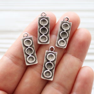 May include: Four silver charm pendants shaped like traffic lights with three round lights each.