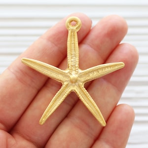 May include: Gold-toned metal starfish charm with a textured surface and a loop at the top for attaching to jewellery or crafts.