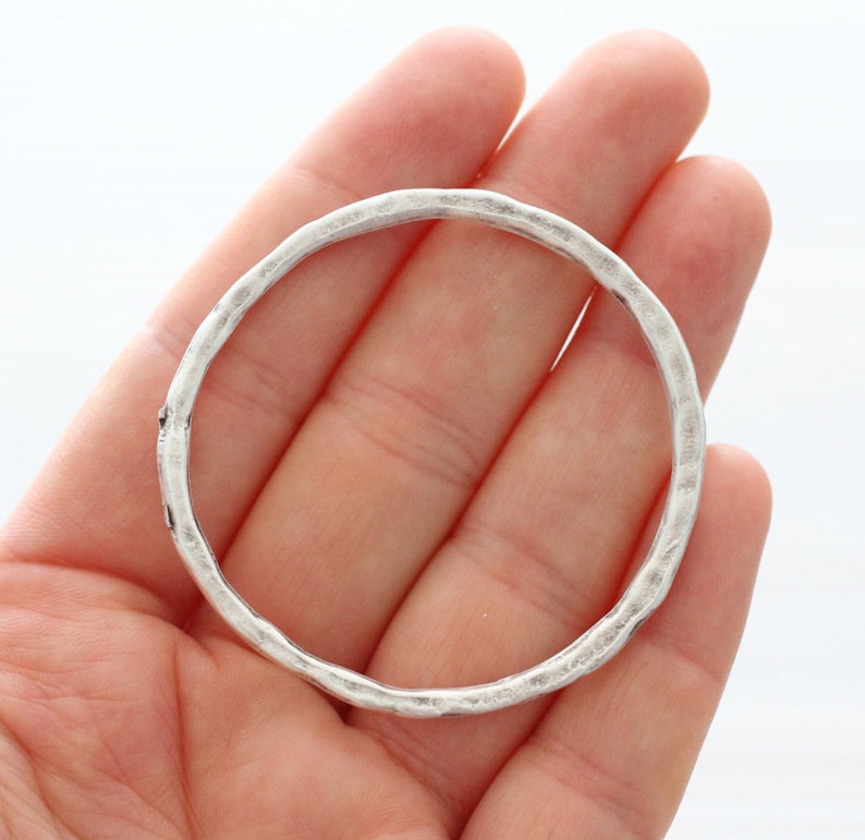 Puede incluir: Un brazalete de plata con textura martillada.