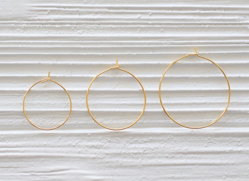 Puede incluir: Tres pendientes de aro dorados de diferentes tama&ntilde;os. Los pendientes son simples y elegantes, y ser&iacute;an una gran adici&oacute;n a cualquier colecci&oacute;n de joyas.