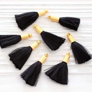 May include: Eight black tassel trim with gold metal caps. The tassels are made of soft, silky fibers and are perfect for adding a touch of elegance to any project.