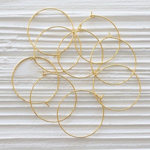 Puede incluir: Un conjunto de ocho aros de oro. Los aros est&aacute;n dispuestos en un patr&oacute;n circular, con algunos superpuestos.