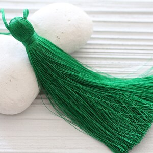 May include: A bright green tassel with a long, flowing fringe. The tassel is made of soft, silky material and is perfect for adding a touch of elegance to any project.
