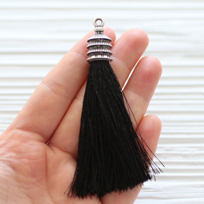 May include: Black tassel with a silver pagoda-shaped top.
