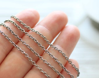 May include: Four silver chains of different thicknesses, displayed on a hand.