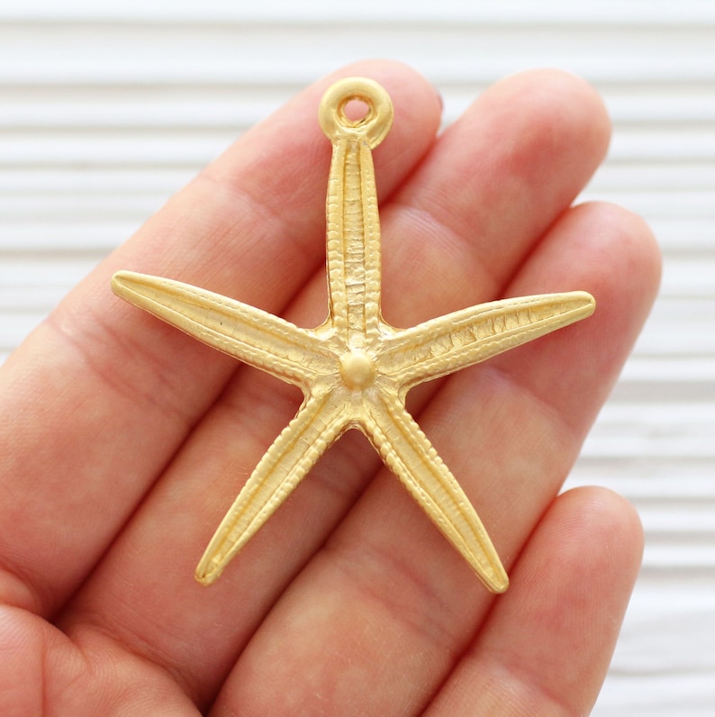 May include: Gold-toned metal starfish charm with a textured surface and a loop at the top for attaching to jewellery or crafts.