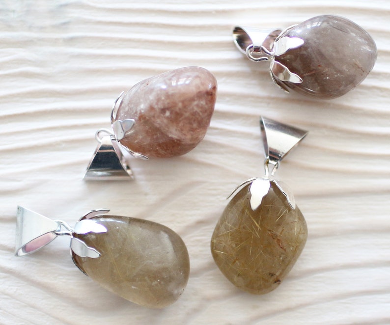 May include: Four natural stone pendants with silver bail settings. The stones are various shades of brown and clear with gold flecks.