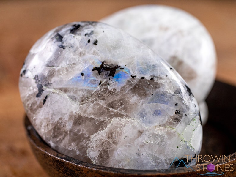 These Moonstone crystal carved polished palm stones range in a variety of handheld sizes.  Rainbow moonstone is white with black flecks and rainbow flashes.
Crystals are nature-made therefore each one is unique in appearance.
