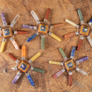 These crystal carved polished generators are a rainbow chakra crystal pyramid surrounded by 7 small points in each color of the rainbow chakras.
Crystals are nature-made therefore each one is unique in appearance.