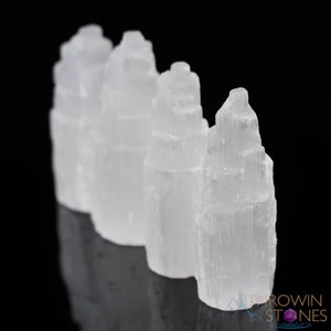 These white Selenite crystal carved raw tiered towers range in a variety of handheld sizes.  
Crystals are nature-made therefore each one is unique in appearance.