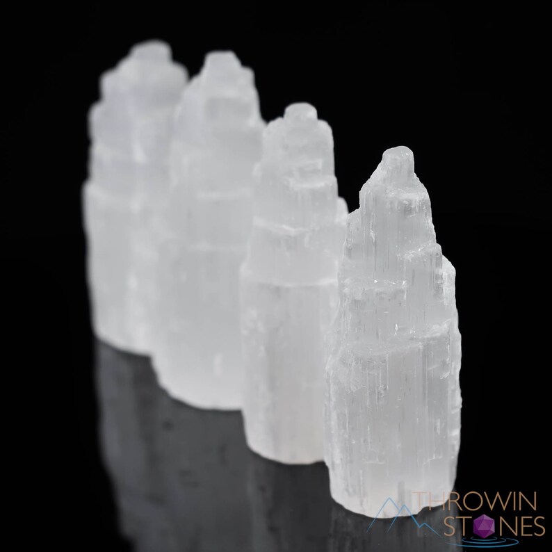 These white Selenite crystal carved raw tiered towers range in a variety of handheld sizes.  
Crystals are nature-made therefore each one is unique in appearance.