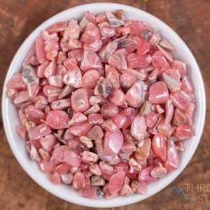 Rhodochrosite Crystal Chips. These stones are light pink to bright pink and often include a white banding. They are great for jewelry making and crystal decor. Each specimen is unique and varies in color, shape, and pattern. Listing has variations.