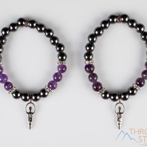 These purple Amethyst and grey Hematite crystal bracelets have round beads strung on elastic.  They feature a silver Goddess Charm.
Crystals are nature-made therefore each one is unique in appearance.