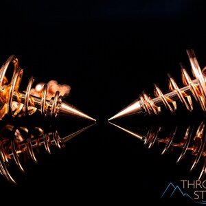 These copper pendulums are wire spirals with a pointed tip, with a copper chain and bead.