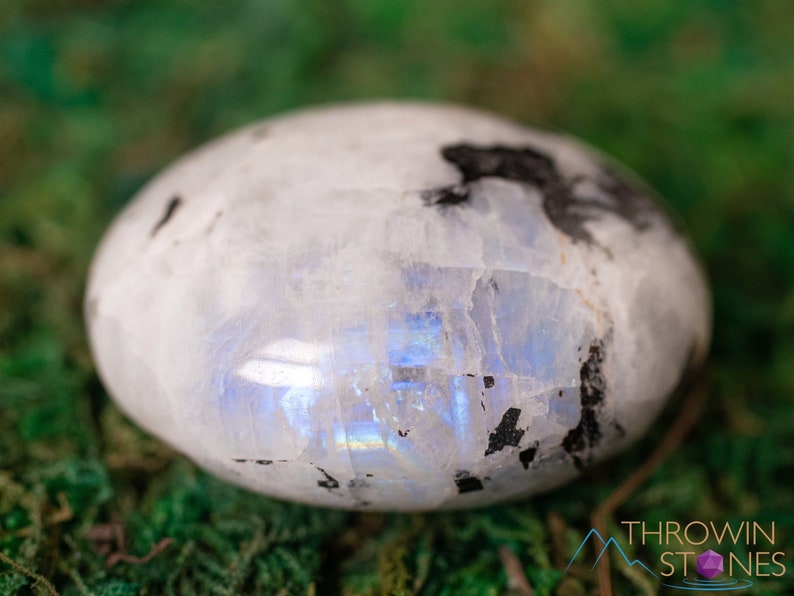 These Moonstone crystal carved polished palm stones range in a variety of handheld sizes.  Rainbow moonstone is white with black flecks and rainbow flashes.
Crystals are nature-made therefore each one is unique in appearance.