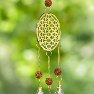 These are small brass wind chimes in the shape of a disc with the "flower of life" sacred geometry design, with bells and Rudraksha beads.