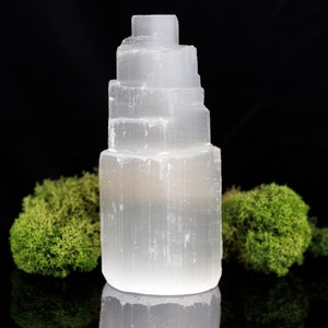 These white Selenite crystal carved raw tiered towers range in a variety of handheld sizes.  
Crystals are nature-made therefore each one is unique in appearance.