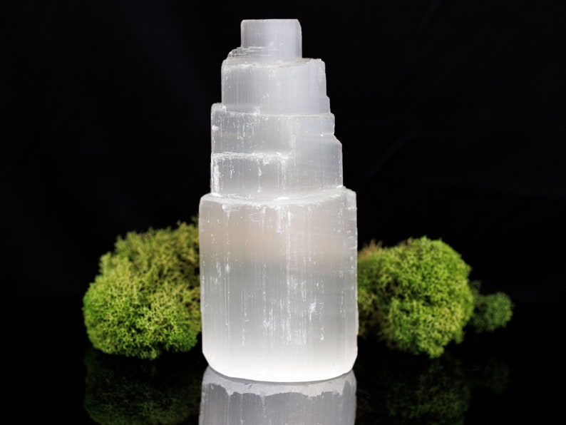 These white Selenite crystal carved raw tiered towers range in a variety of handheld sizes.  
Crystals are nature-made therefore each one is unique in appearance.