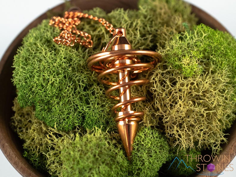 These copper pendulums are wire spirals with a pointed tip, with a copper chain and bead.