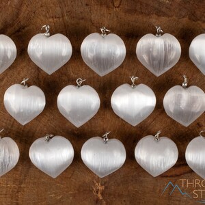 These chatoyant white Selenite crystal pendants are heart shaped, with a silver bail. 
Crystals are nature-made therefore each one is unique in appearance.