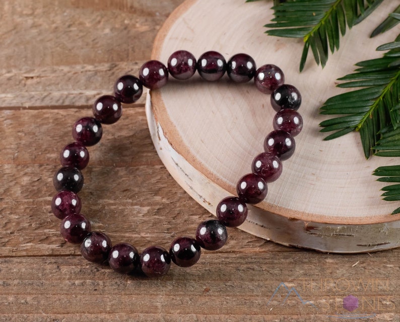 These maroon Garnet crystal bracelets have spherical beads strung on elastic for an endless bracelet.  
Crystals are nature-made therefore each one is unique in appearance.