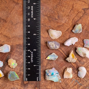 These raw Opal crystals are chunk shaped and rainbow colored with patches of tan matrix.
Crystals are nature-made therefore each one is unique in appearance.