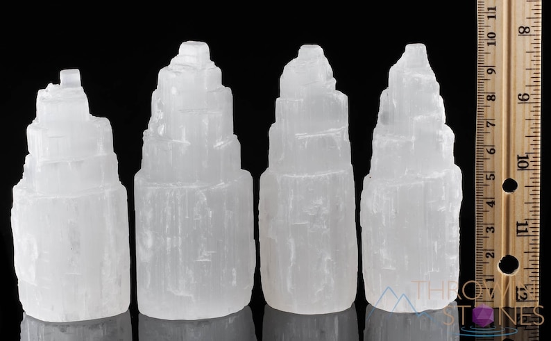 These white Selenite crystal carved raw tiered towers range in a variety of handheld sizes.  
Crystals are nature-made therefore each one is unique in appearance.