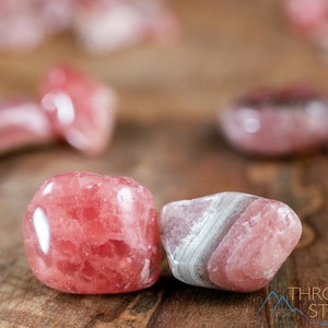 Rhodochrosite Crystal Chips. These stones are light pink to bright pink and often include a white banding. They are great for jewelry making and crystal decor. Each specimen is unique and varies in color, shape, and pattern. Listing has variations.