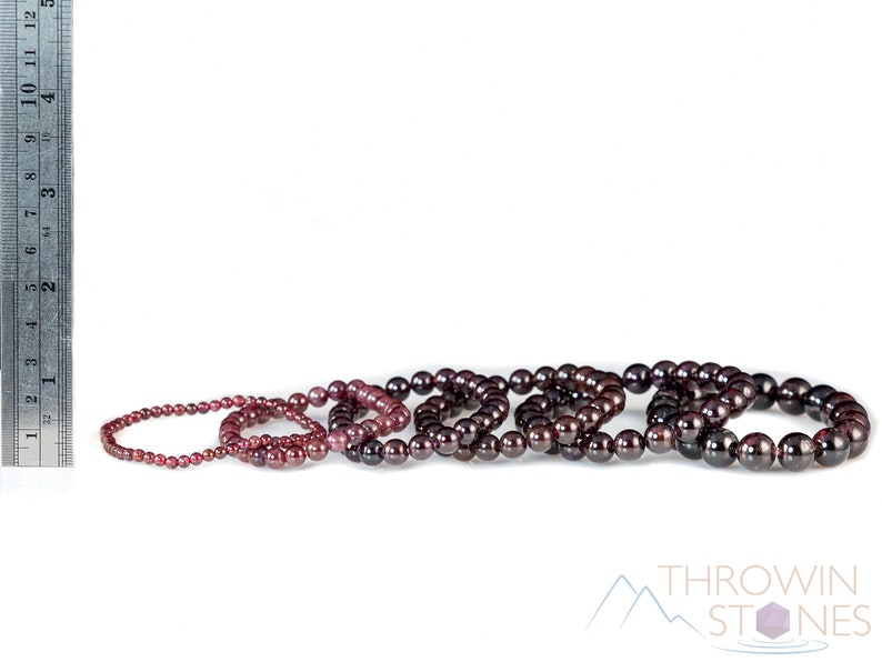 These maroon Garnet crystal bracelets have spherical beads strung on elastic for an endless bracelet.  
Crystals are nature-made therefore each one is unique in appearance.