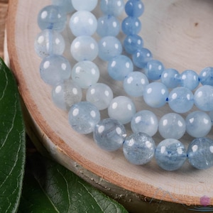 Handcrafted Aquamarine round beaded bracelet. These polished, blue beads are drilled and strung on elastic cord. Each crystal bracelet is unique in shape, color, and pattern and has a wrist circumference of about 6 to 7 inches. Listing has variations