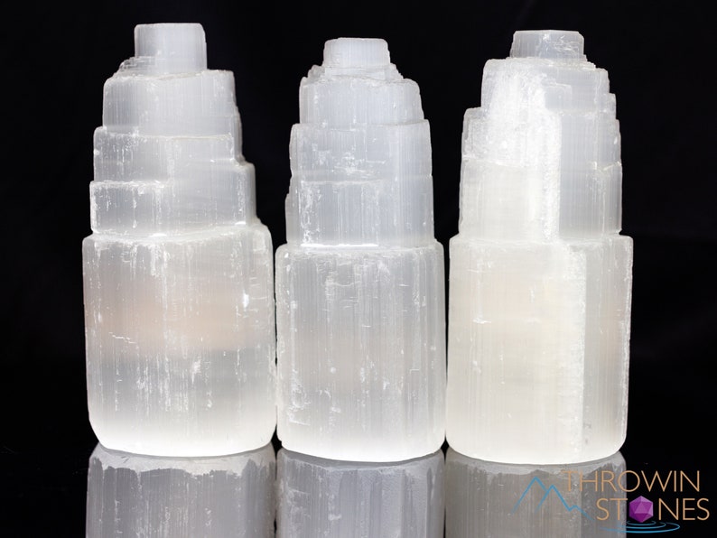 These white Selenite crystal carved raw tiered towers range in a variety of handheld sizes.  
Crystals are nature-made therefore each one is unique in appearance.