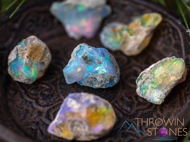 These raw Opal crystals are chunk shaped and rainbow colored with patches of tan matrix.
Crystals are nature-made therefore each one is unique in appearance.