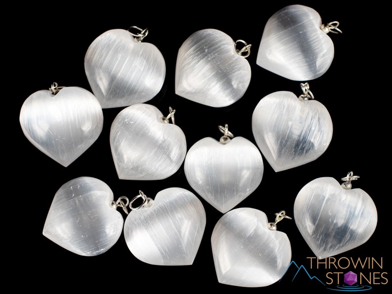 These chatoyant white Selenite crystal pendants are heart shaped, with a silver bail. 
Crystals are nature-made therefore each one is unique in appearance.