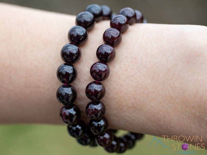 These maroon Garnet crystal bracelets have spherical beads strung on elastic for an endless bracelet.  
Crystals are nature-made therefore each one is unique in appearance.