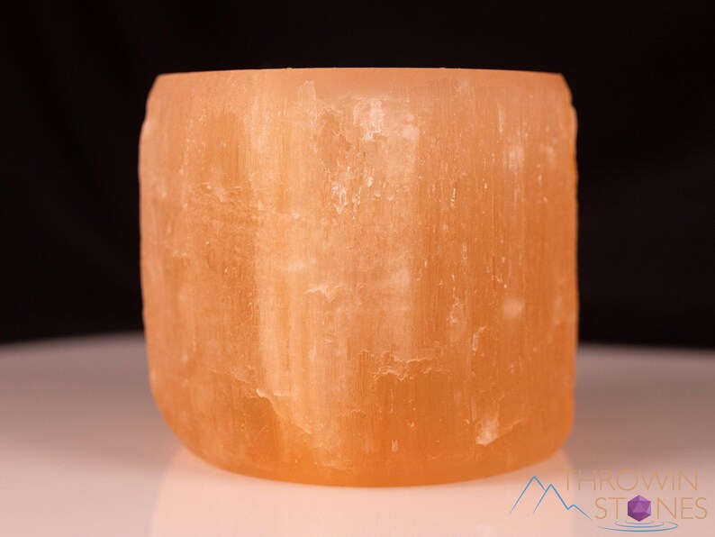 These peachy orange Selenite crystal carved raw cylindrical votive candle holders range in a variety of sizes.  
Crystals are nature-made therefore each one is unique in appearance.